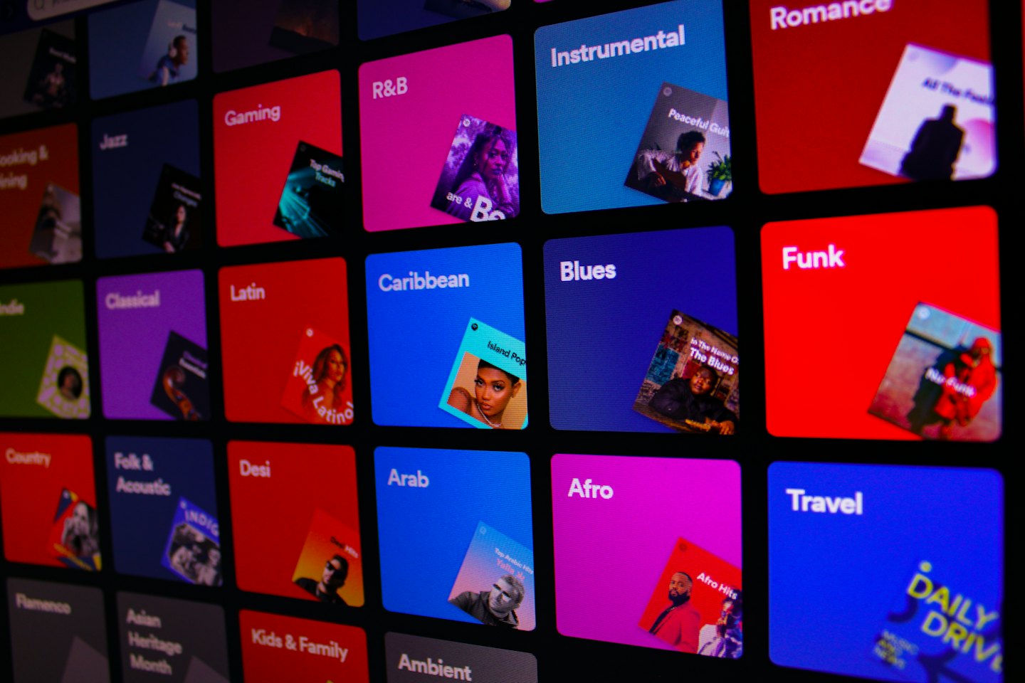 Digitaler Bildschirm zeigt bunte Musikgenre-Kacheln mit Albumcovern.