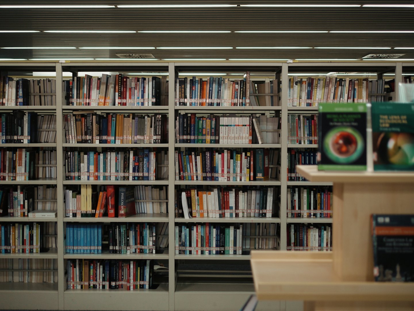 Metallregale voller Bücher stehen in einer Bibliothek.